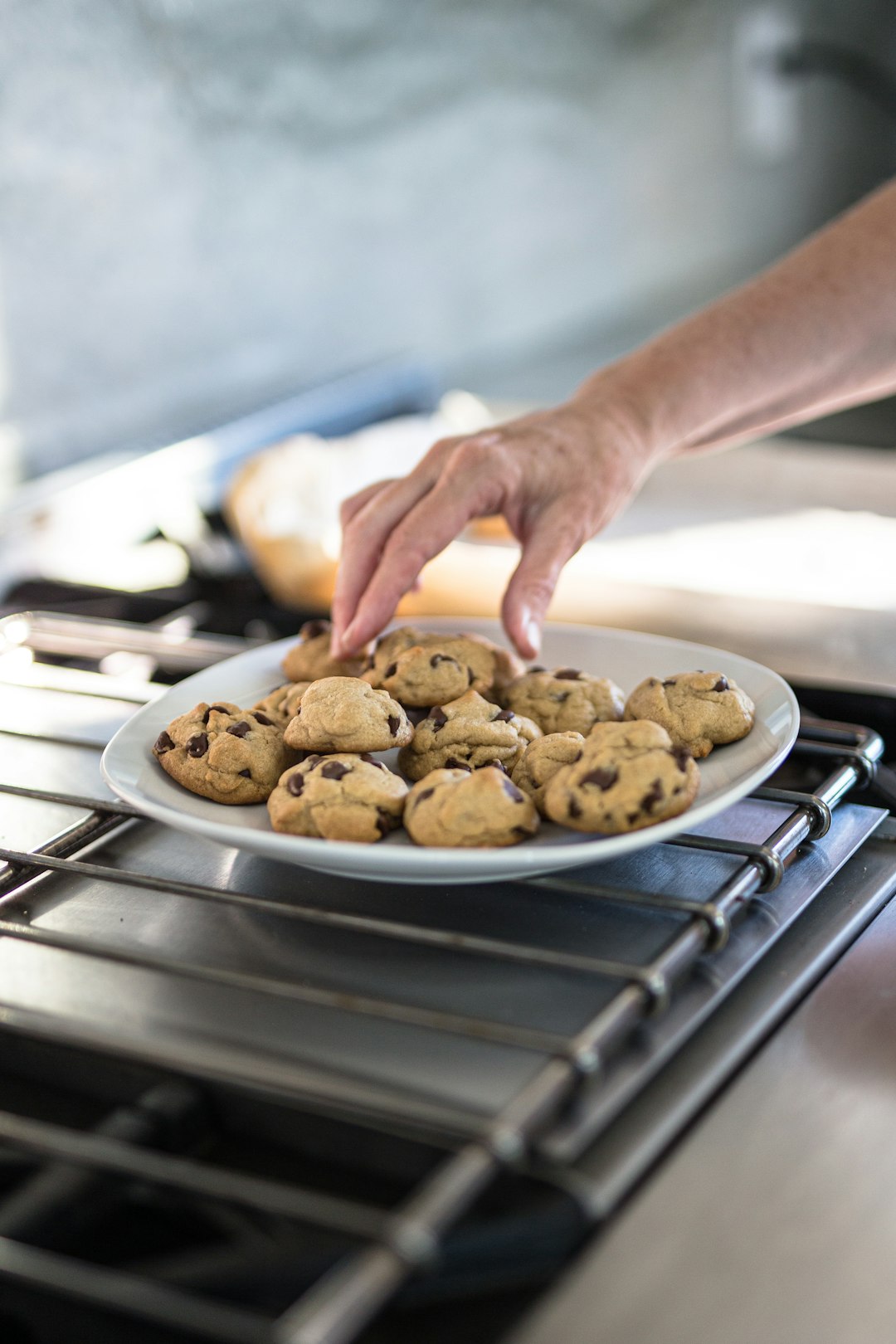 person holding brown cookies on stainless steel tray