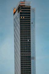 A sleek, minimalist construction site with clean lines and workers collaborating under a bright sky.