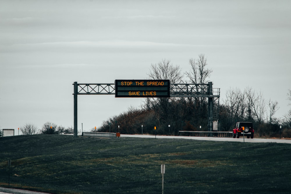 a sign on the side of a road that says stop the spread save lives