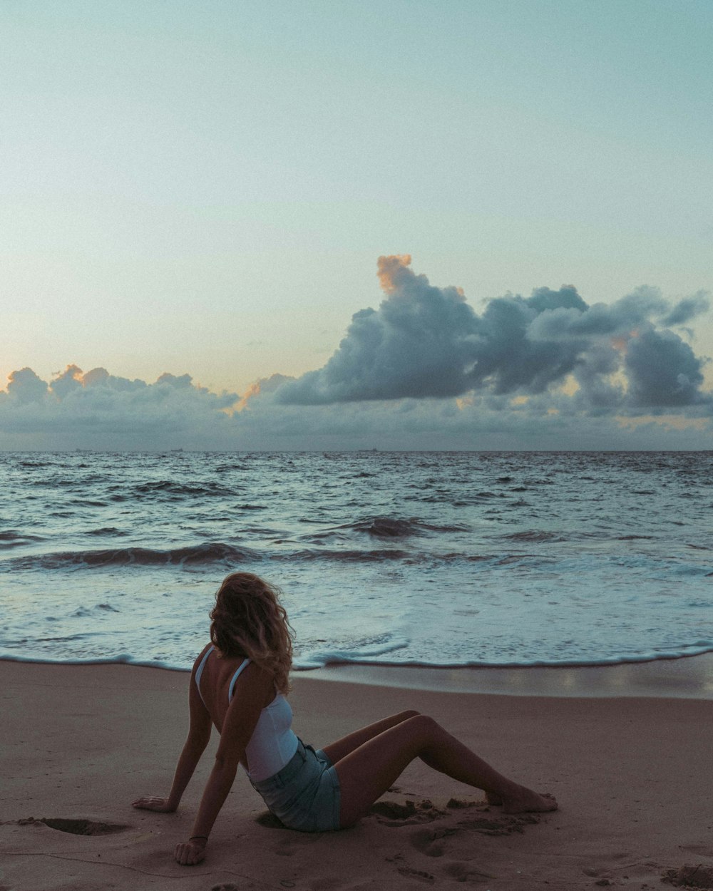 woman in blue bikini sitting on beach shore during daytime