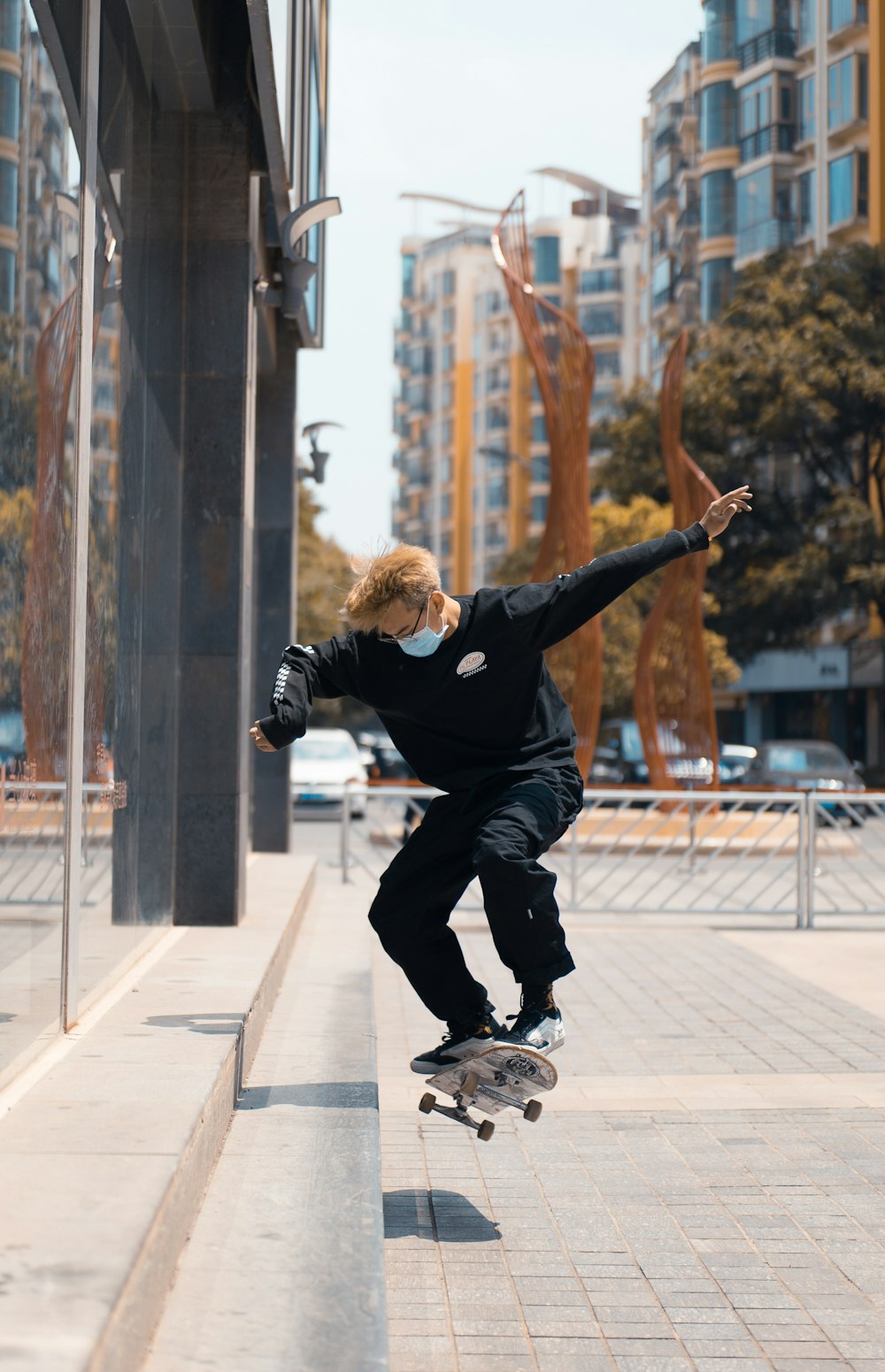 man in black jacket and black pants jumping on gray concrete floor during daytime