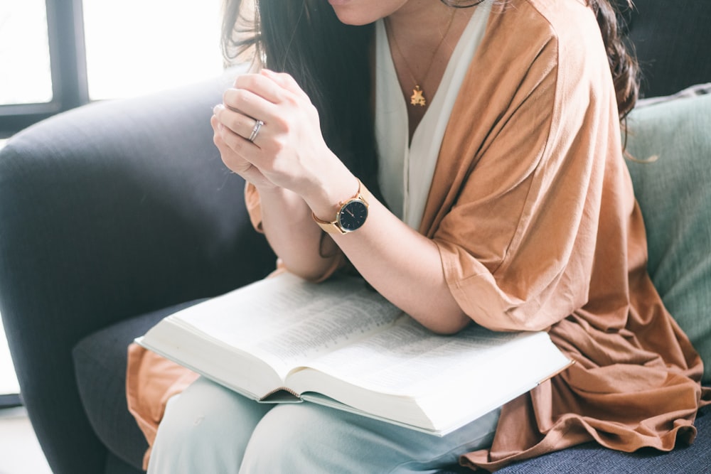 woman in brown robe sitting on black couch