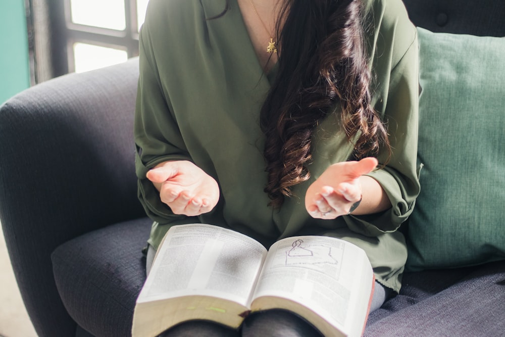 woman in green coat reading book