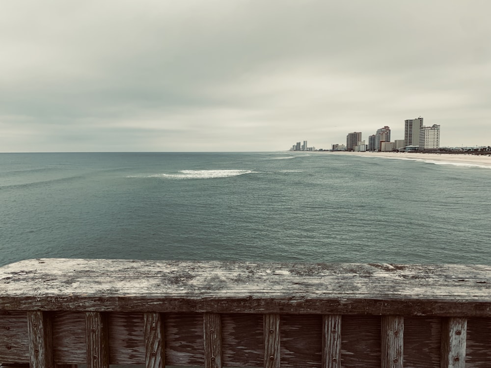 brown wooden fence near body of water during daytime