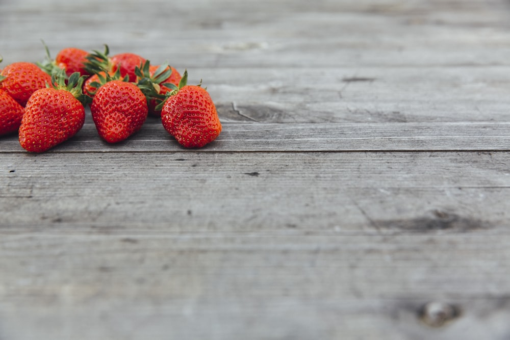 red strawberries on brown wooden table