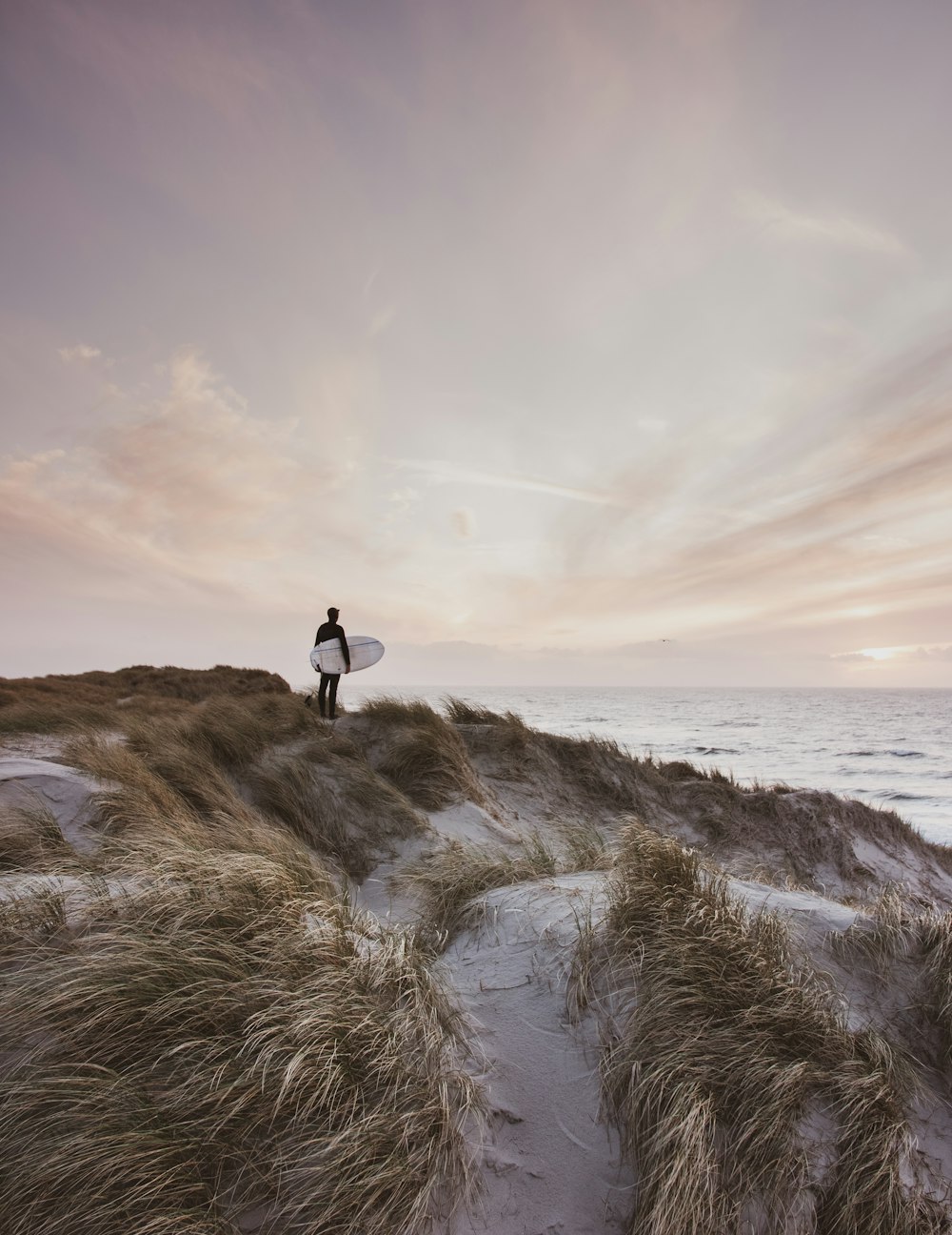 person standing on rock formation near sea during daytime