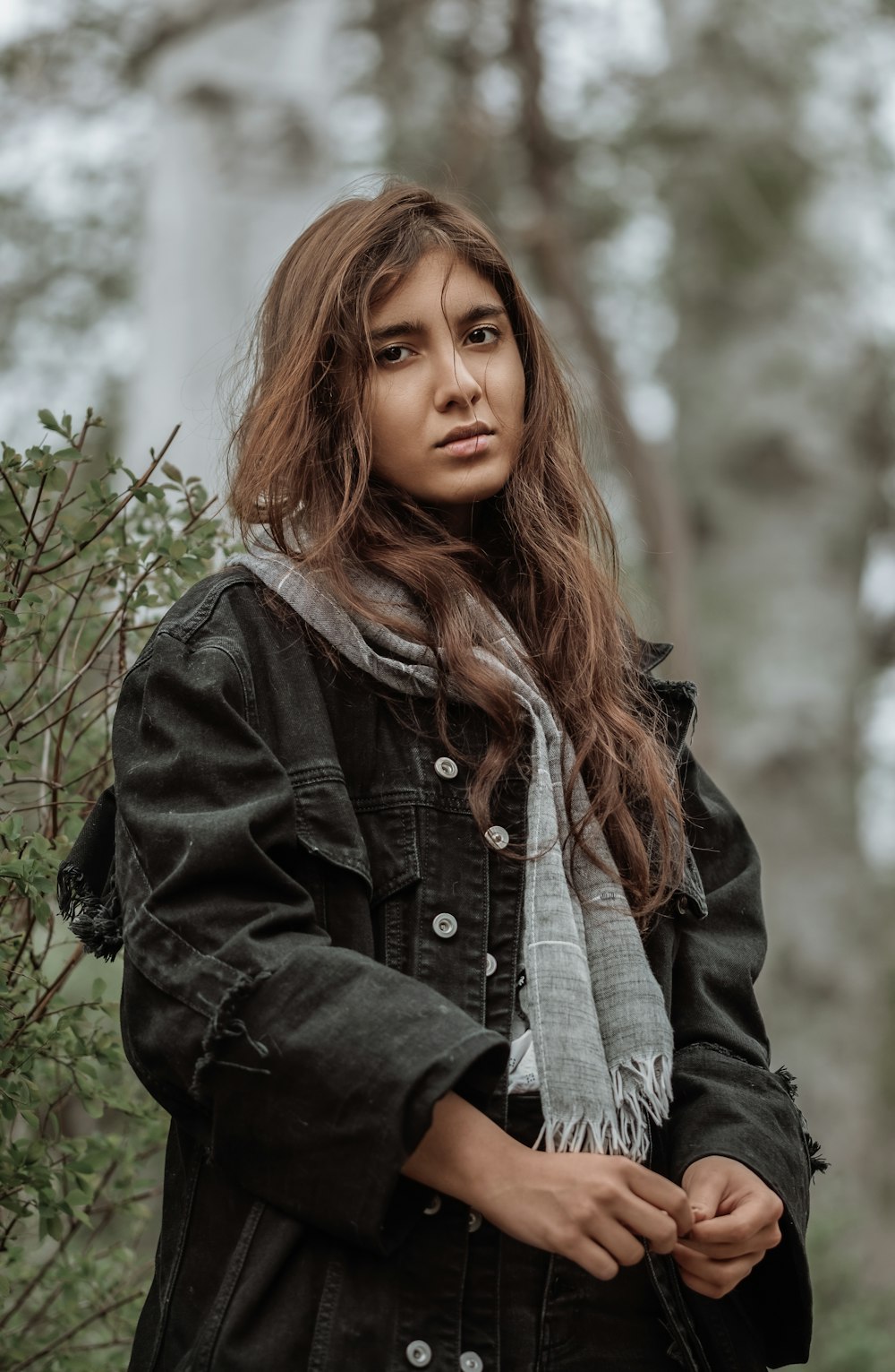 woman in black jacket standing near green plants during daytime