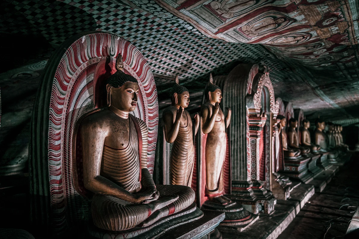 Row of ancient Buddha statues inside the Dambulla cave temple, Sri Lanka
