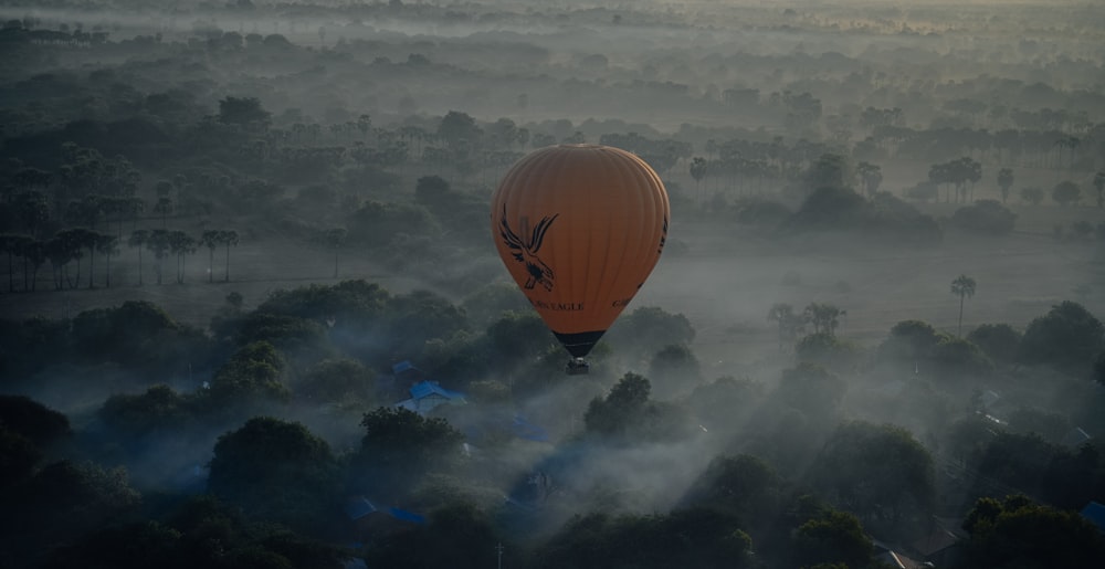 brown hot air balloon flying over the clouds