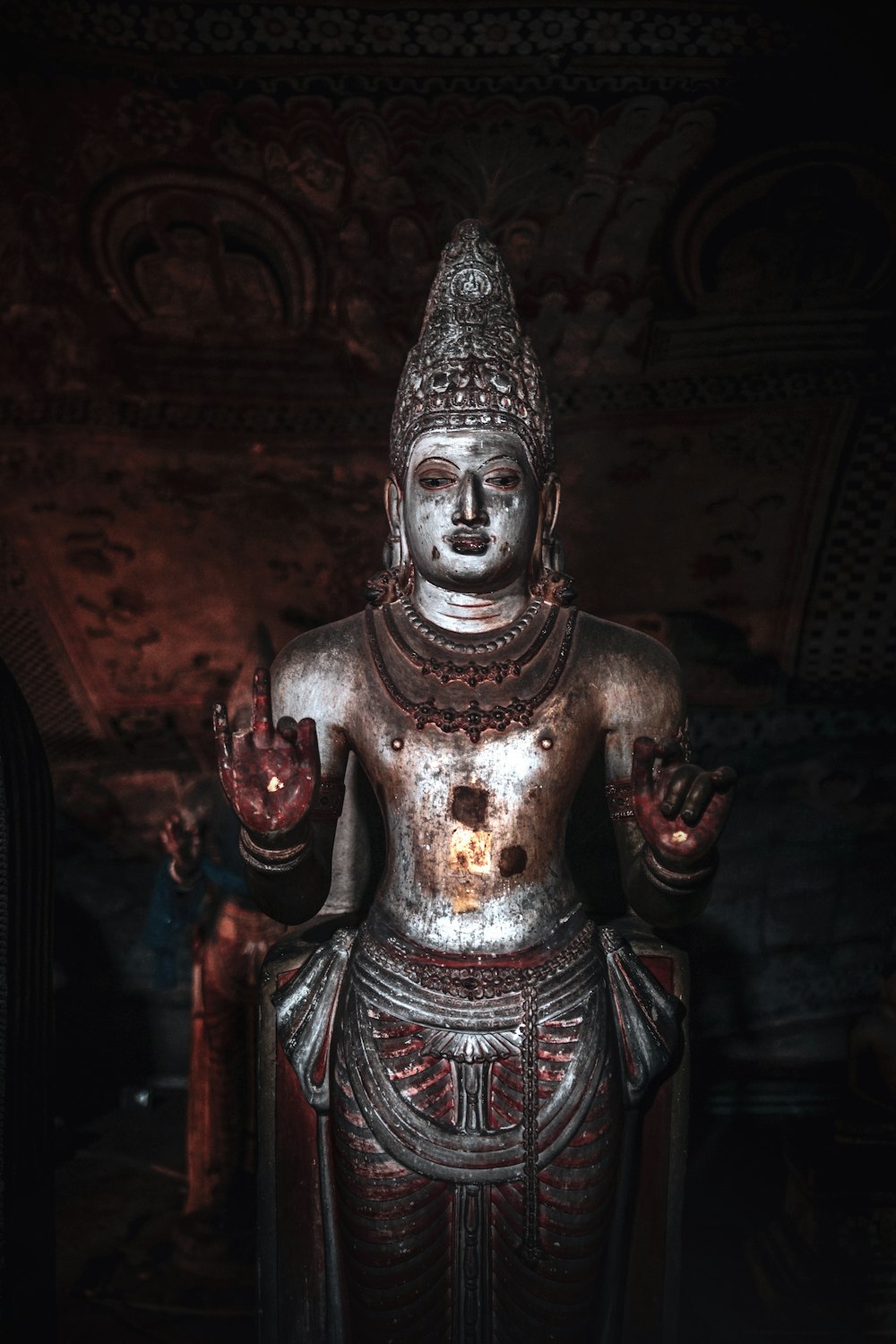 person wearing silver mask and red and black suit