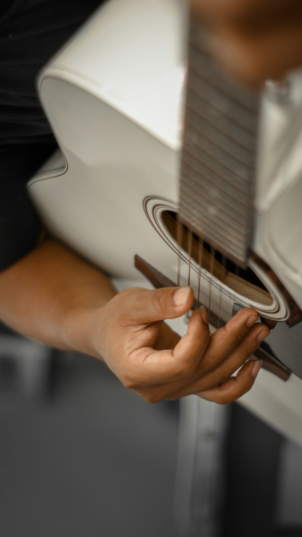 person playing white and black acoustic guitar