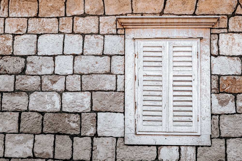 black wooden window on brown brick wall