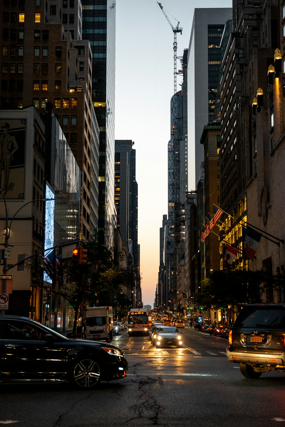 cars on road in between high rise buildings during daytime