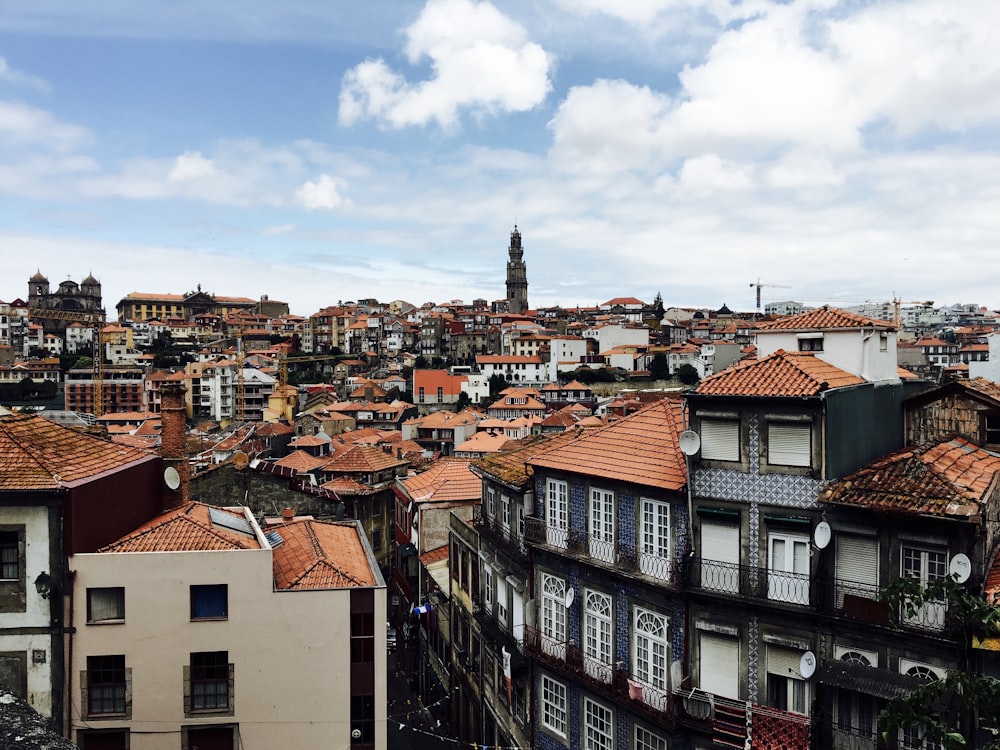 white and brown concrete buildings under white clouds and blue sky during daytime