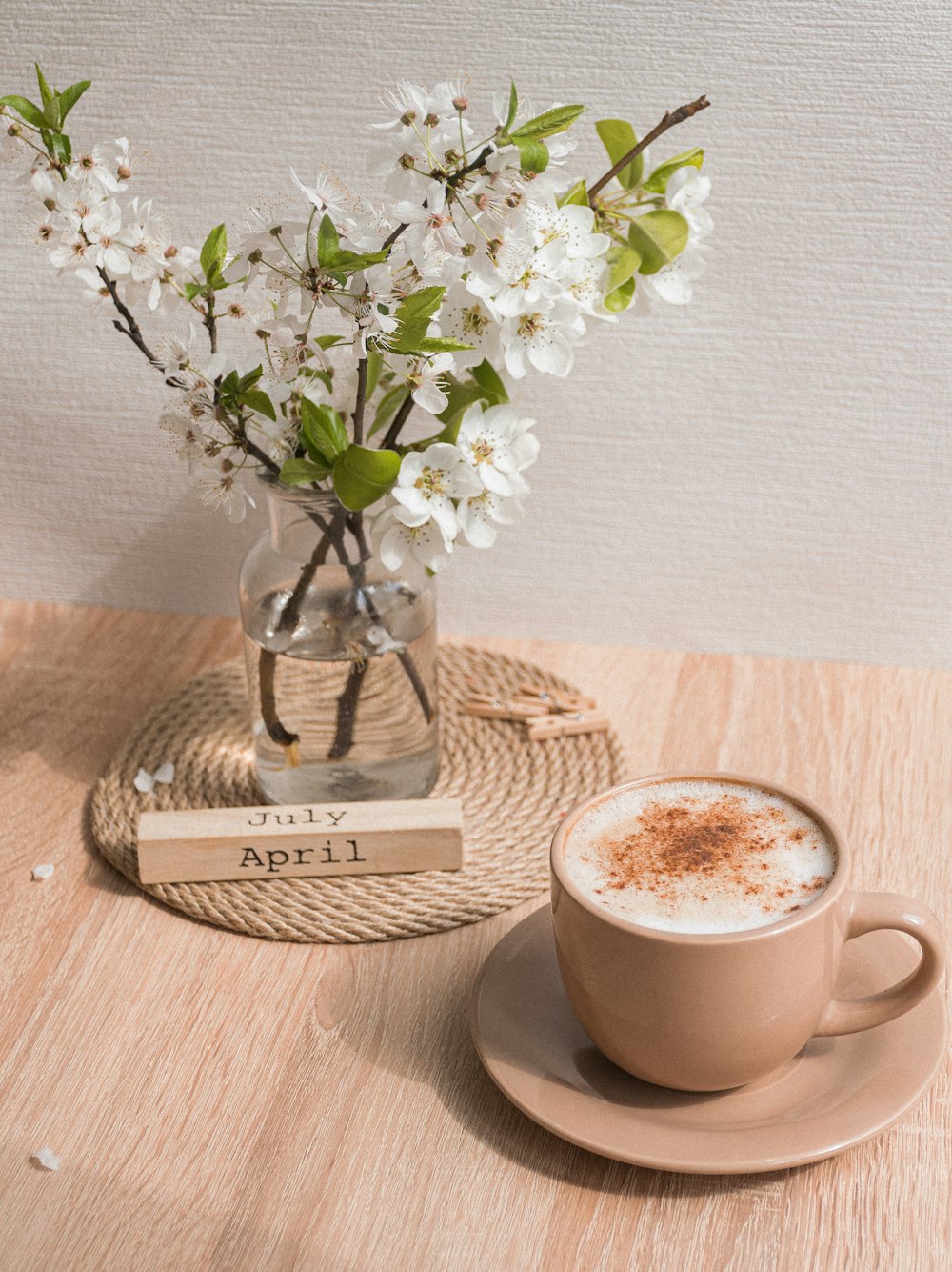 white ceramic cup with coffee on brown wooden coaster