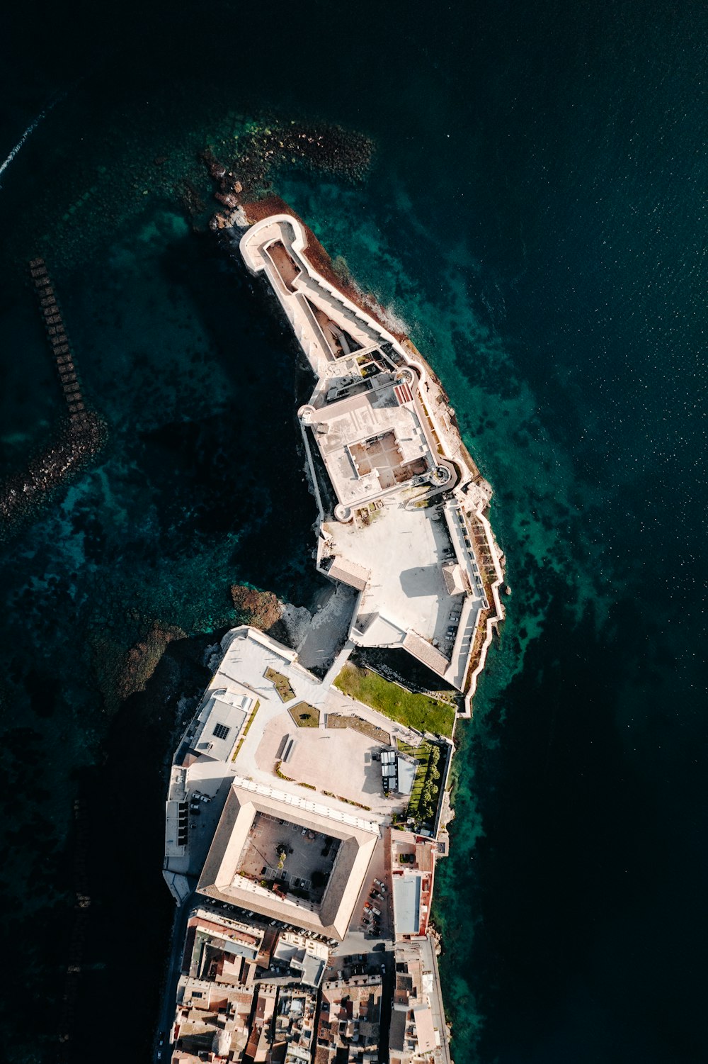 Vue aérienne d’un bâtiment blanc près d’un plan d’eau pendant la journée