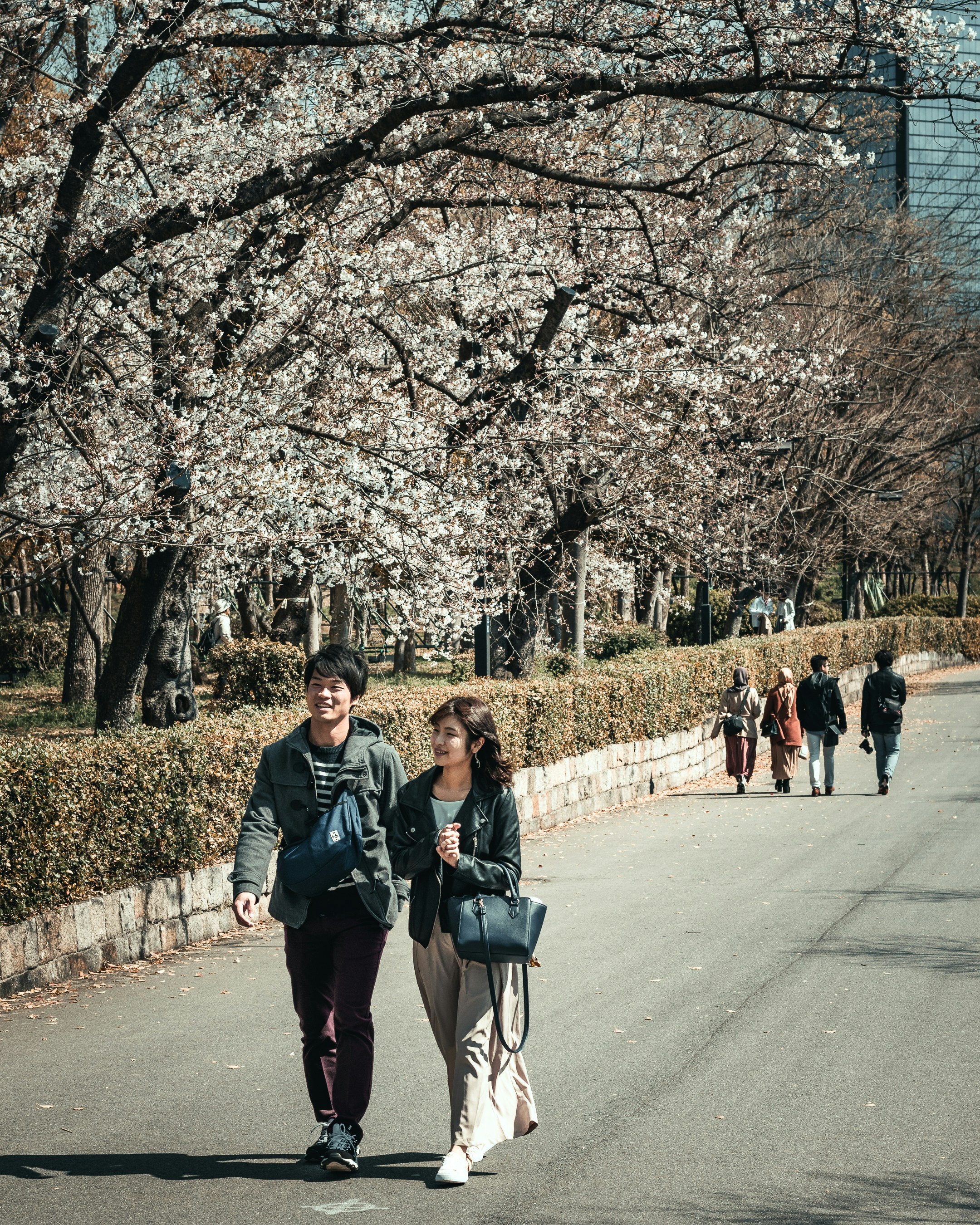 woman in black jacket standing on gray asphalt road during daytime