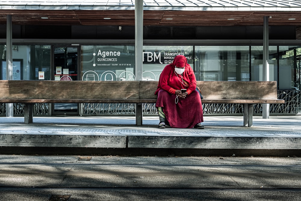 woman in red coat sitting on bench