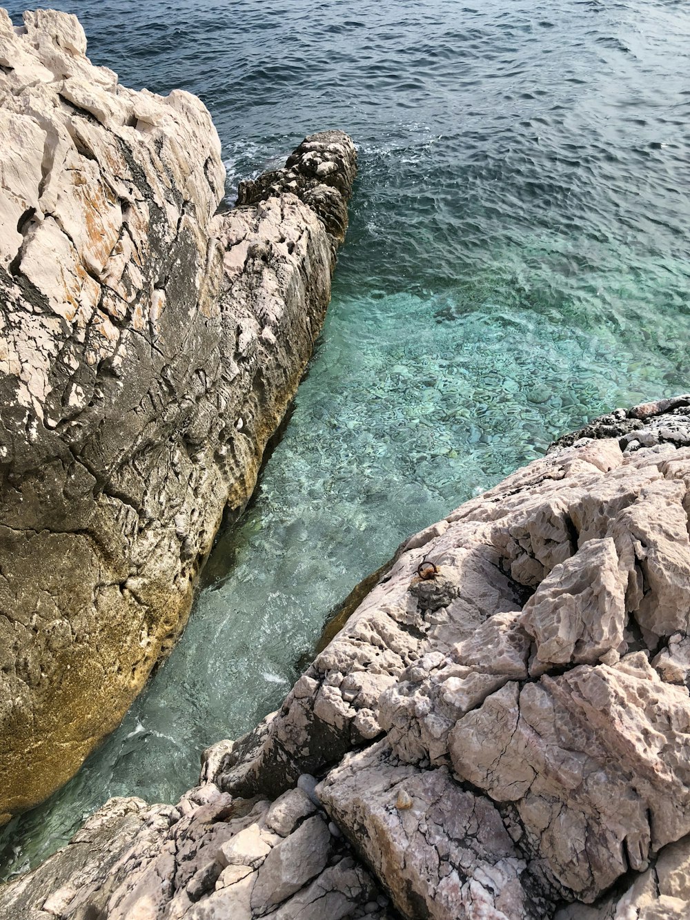 brown rock formation beside body of water during daytime