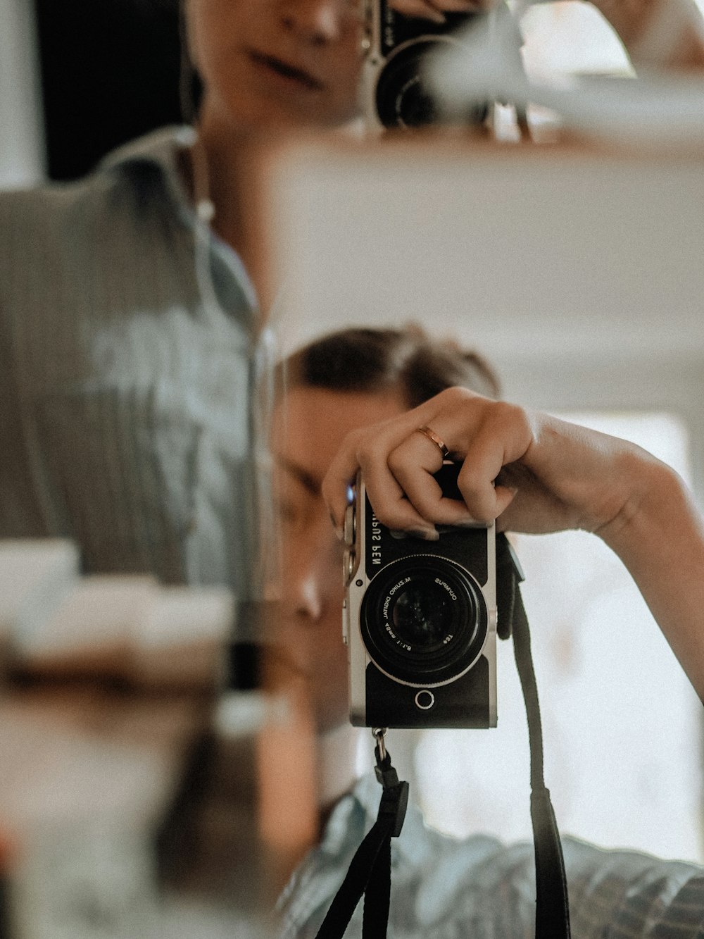 man in gray shirt holding black and silver camera