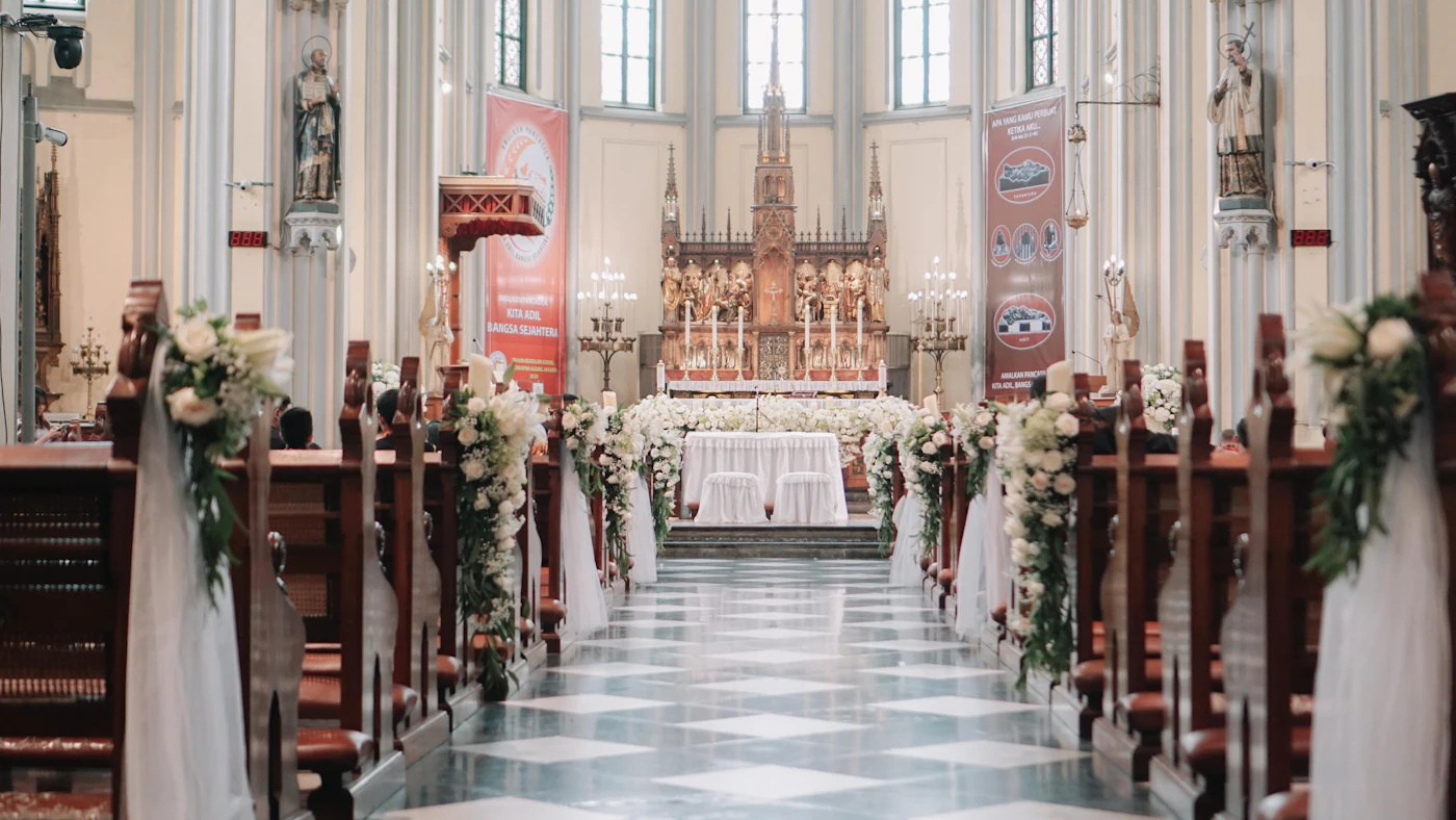 Catholic wedding mass programs with bilingual translations — Guests hold wedding programs during a Nuptial Mass in a Catholic church.