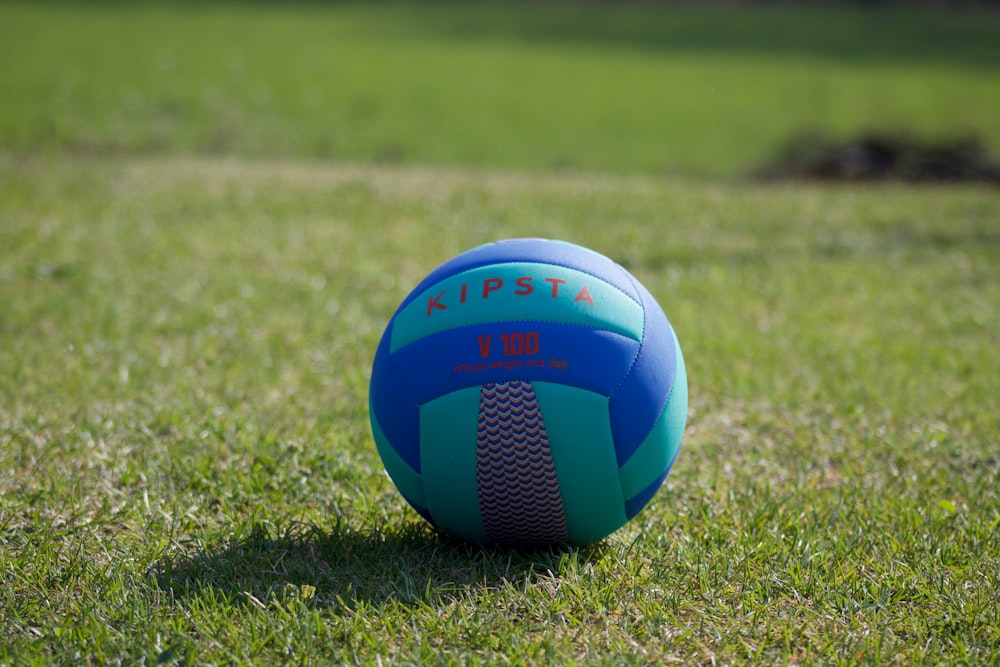 blue yellow and white soccer ball on green grass field during daytime