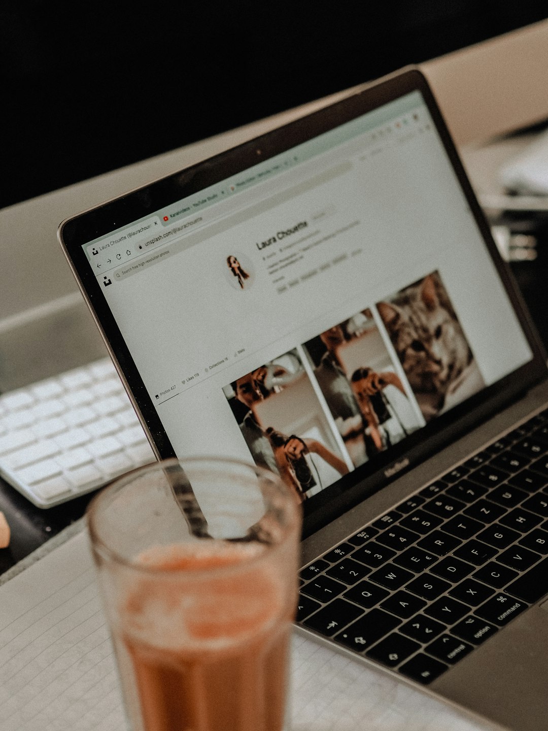 macbook pro with clear drinking glass on it