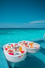 white and red plastic round table with chairs on beach during daytime