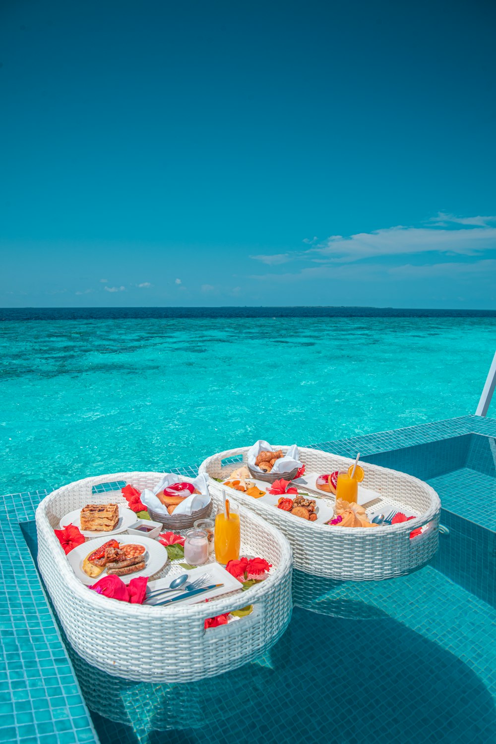 Table ronde en plastique blanc et rouge avec des chaises sur la plage pendant la journée