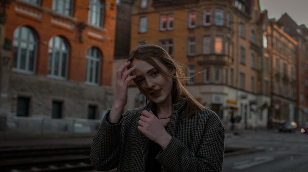 Donna in camicia a maniche lunghe a scacchi bianchi e neri che copre il suo viso con la mano