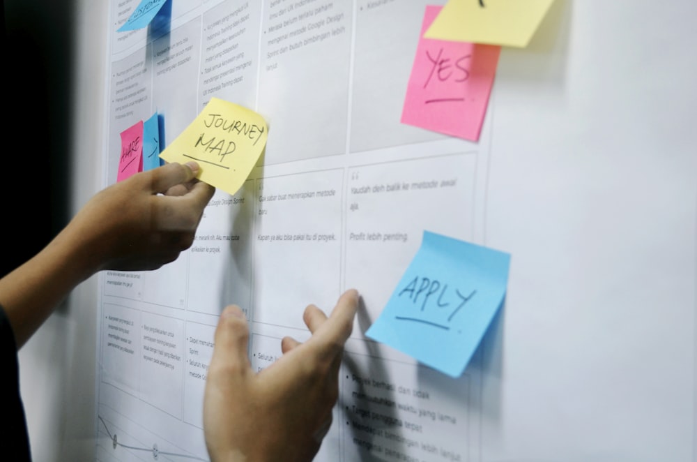 person holding yellow sticky notes