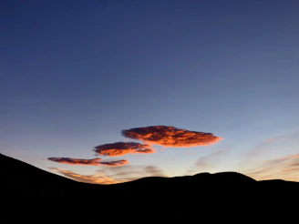 Sunset over the rolling hills of Sierras Bayas with vibrant orange and pink skies