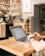 A person happily using a laptop at a cozy cafe.