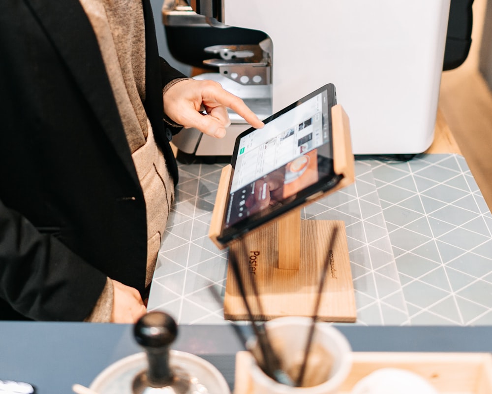 person in black blazer holding black ipad