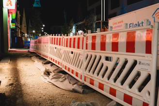Nighttime view of a construction site with illuminated temporary sanitation units and clear wayfinding.