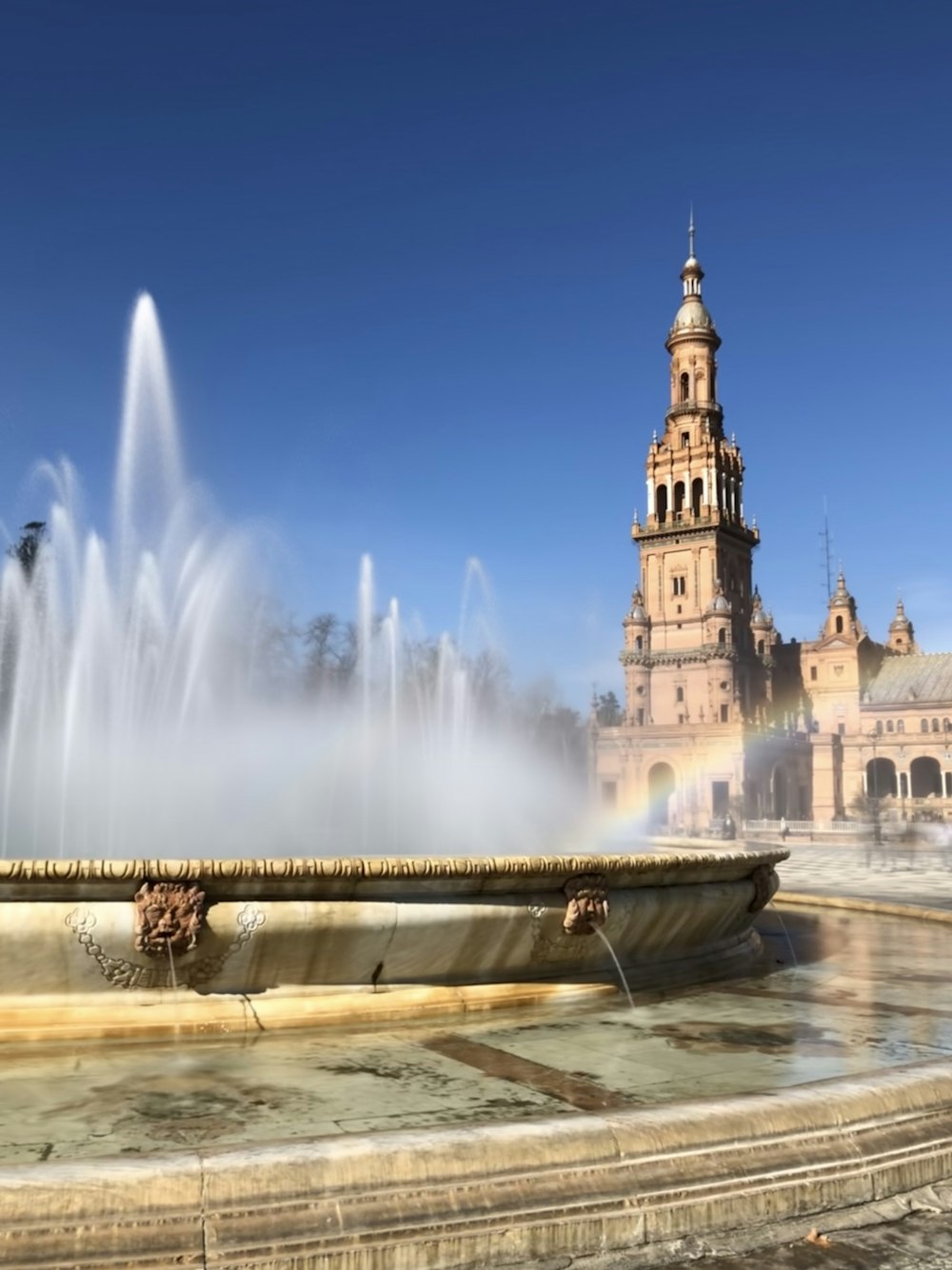 Brunnen vor weißem Betongebäude tagsüber