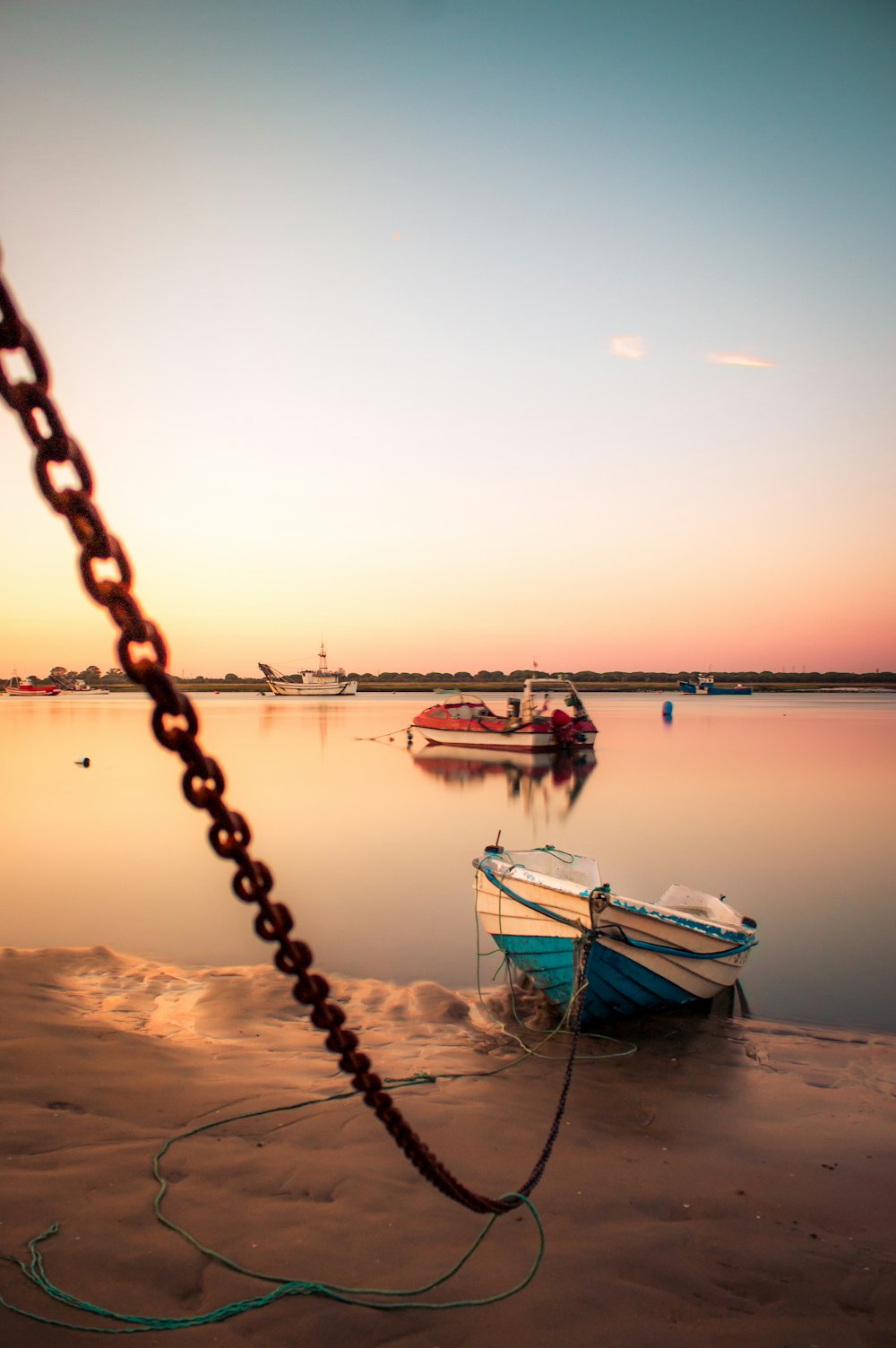 Bateau blanc et bleu sur la mer au coucher du soleil