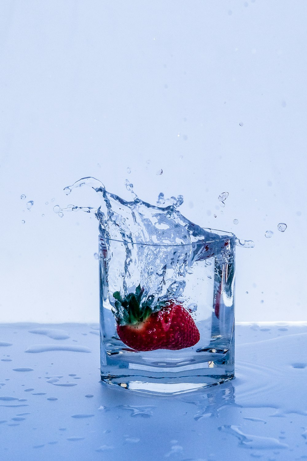 red strawberry in clear glass container