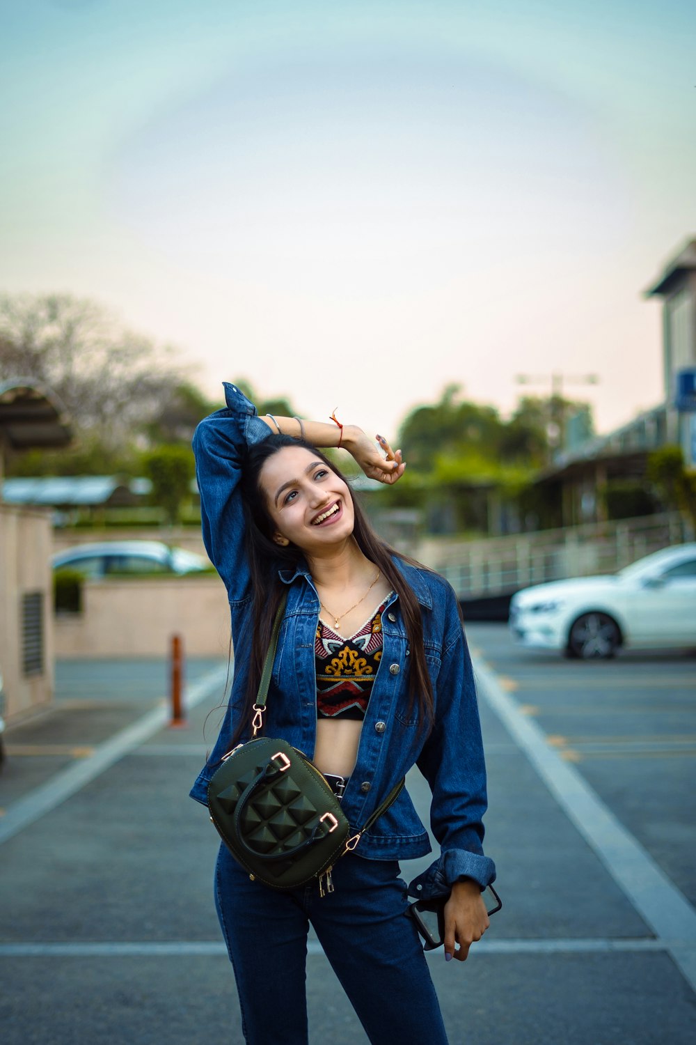 woman in blue denim jacket standing on road during daytime