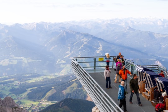 people walking on stairs near mountains during daytime in Dachstein glacier Austria