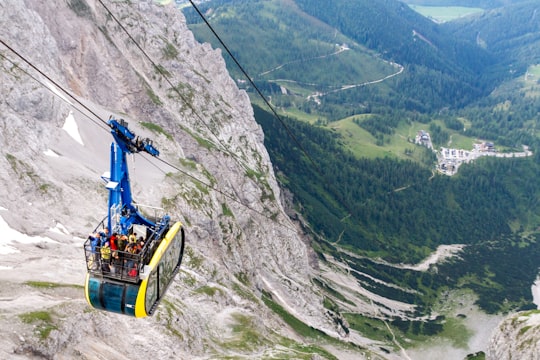 yellow cable car over green mountain during daytime in Dachstein glacier Austria
