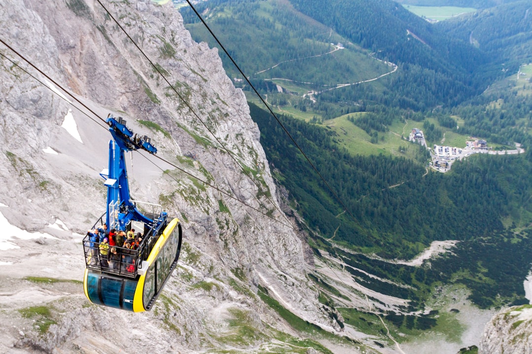 yellow cable car over green mountain during daytime