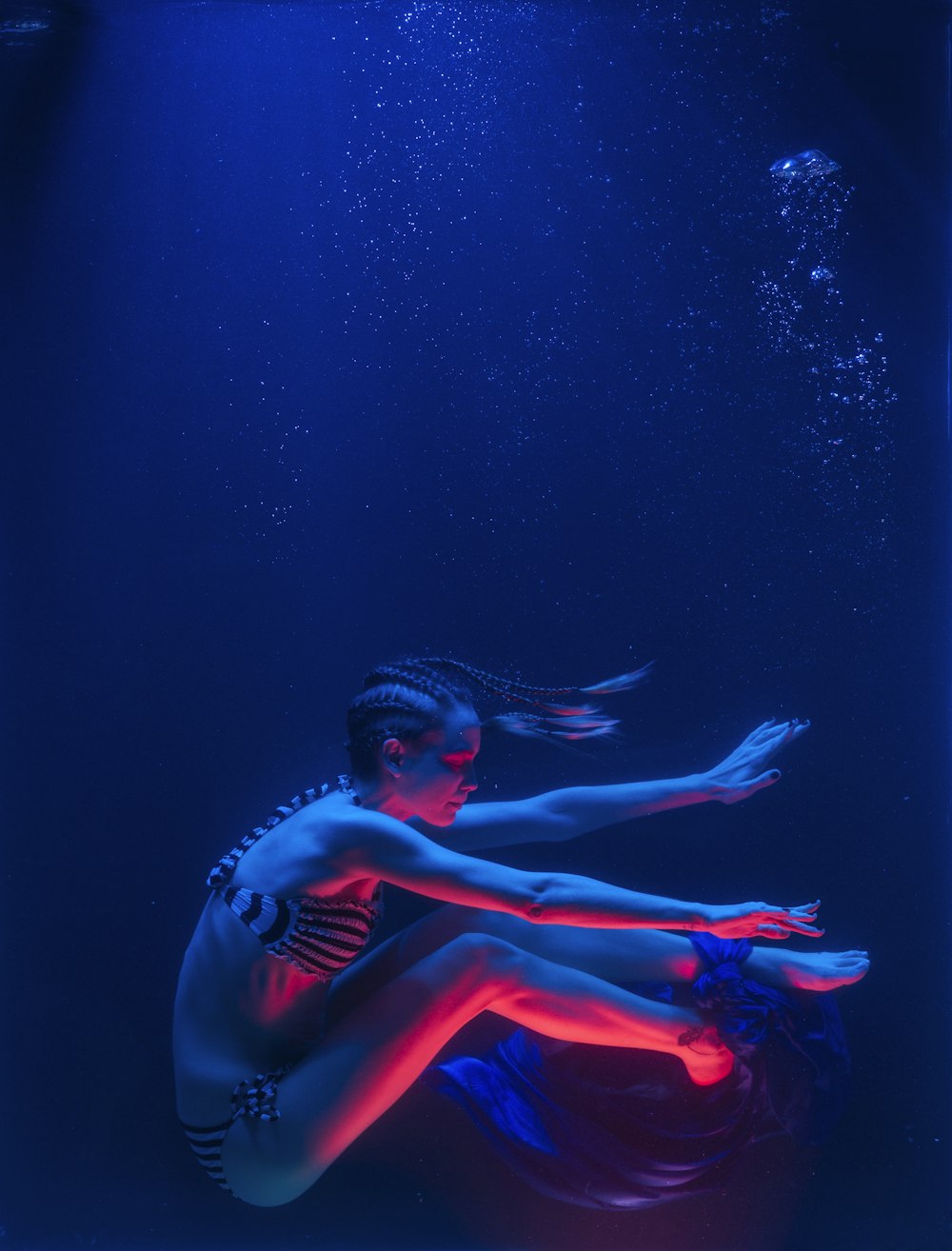 Mujer en bikini rojo bajo el agua