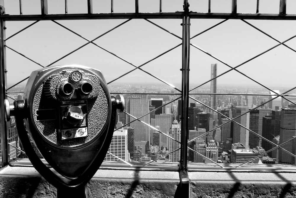 grayscale photo of coin operated telescope