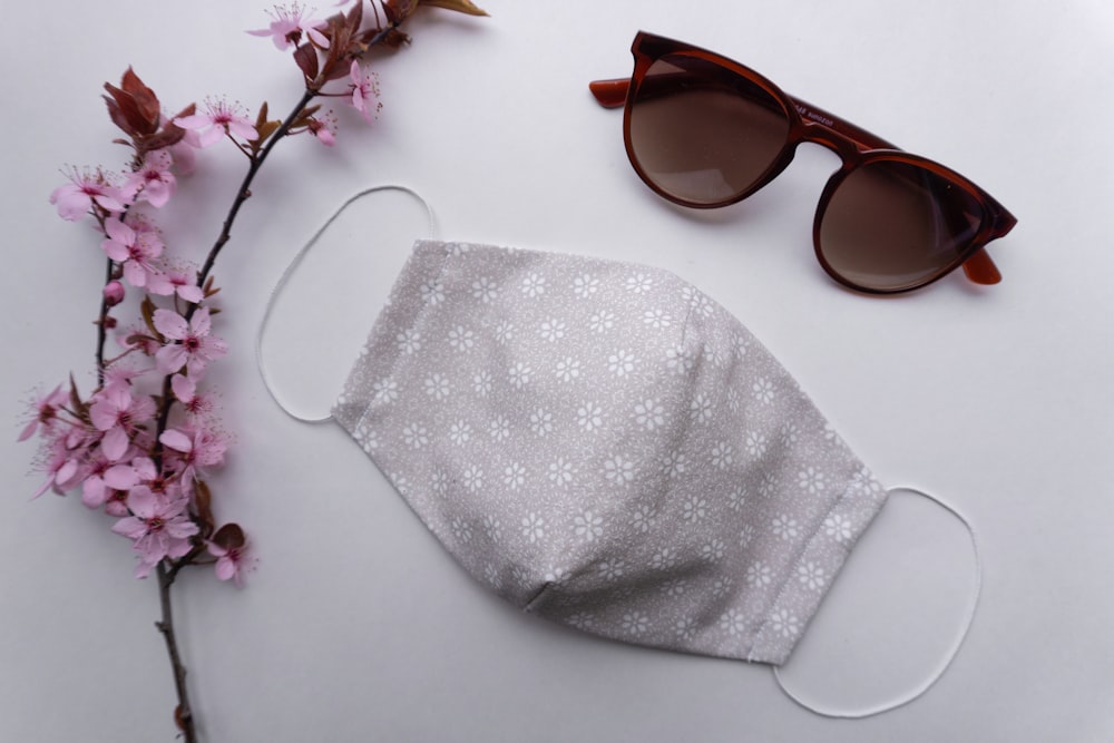 brown framed sunglasses on white textile