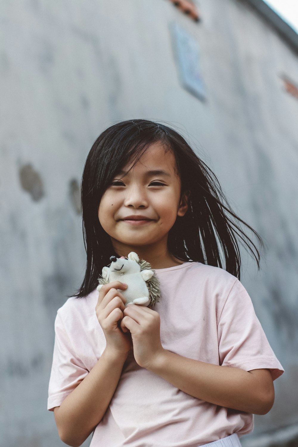 girl in pink crew neck t-shirt holding white flower