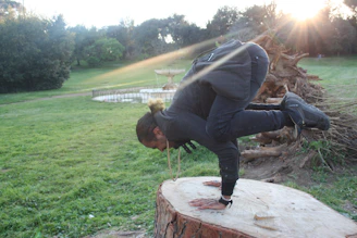 A smiling man finishing a yoga session on a sunlit balcony overlooking nature.