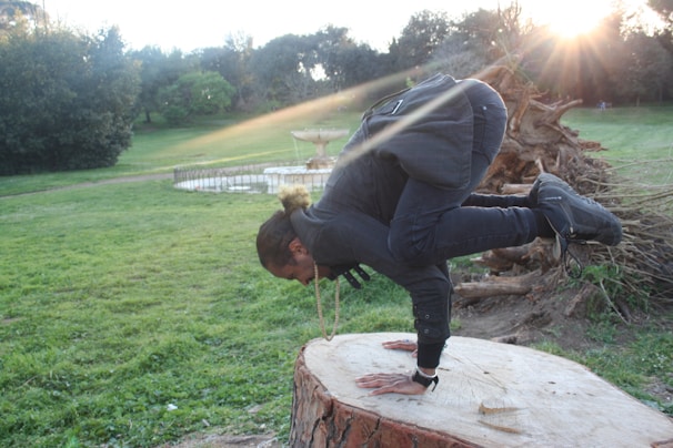 A person practicing yoga outdoors in a green park during sunrise, symbolizing balance and well-being.