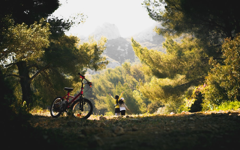 man and woman riding on red and black mountain bike during daytime