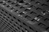 Abstract monochrome shot of intersecting grid lines and shadows on a building facade.